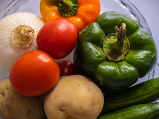 Pepper . tomato . Cucumber . potato . an onion . Garlic . raw .
