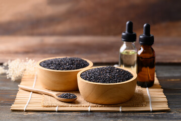 Black sesame seed and oil on wooden background, Food ingredients in Asian cuisine