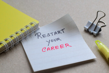 Restart your career handwritten motivational text on sticky note on desk. Selective focus. 