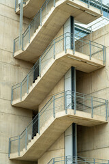Fototapeta premium Spiral cement staircase in industrial area of commercial districts in downtown city neighborhoods with metal hand rails