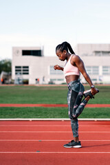 Fototapeta Athlete sprinter stretching her legs obraz