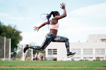African-American athlete sprinter jumping. Sport