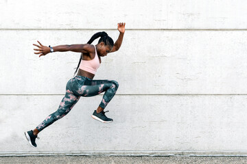 Fototapeta na wymiar African-American athlete sprinter jumping. Sport