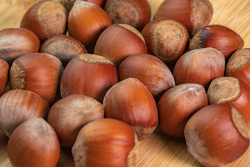 Hazelnuts in shells on wooden background close up. Whole and shelled organic hazelnuts on a wooden table. Nut in shell video concept