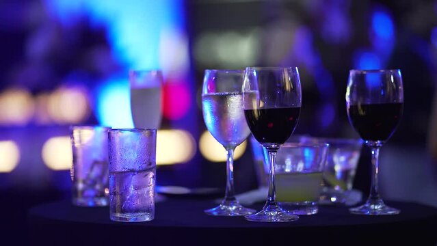 Alcohol drinks on table bar dinner party background. Close-up Champagne cheerful crowd of guests dance.