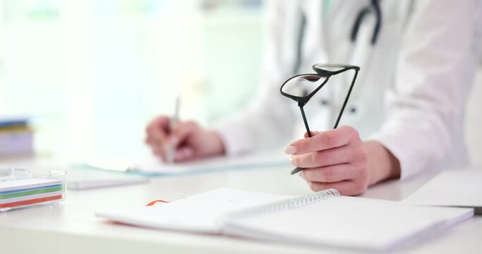 Hands of ophthalmologist write prescription for glasses