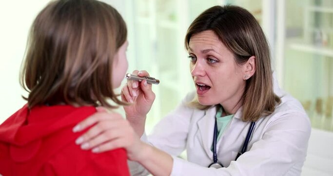 Doctor ENT examination of throat of child in clinic