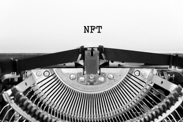 NFT word closeup being typing and centered on a sheet of paper on old vintage typewriter mechanical