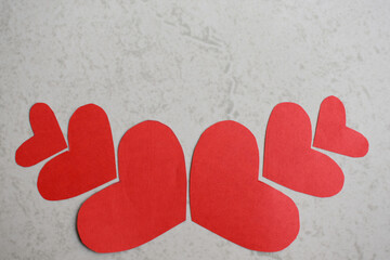 Paper cut red heart shapes on off white background in Pune India