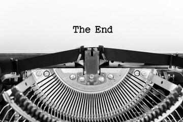 The End phrase closeup being typing and centered on a sheet of paper on old vintage typewriter...