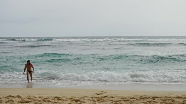 A Beautiful Landscape, a Deserted Beach, far away a Handsome Naked Man Approaches the Ocean and Dives into the Water, Slow motion