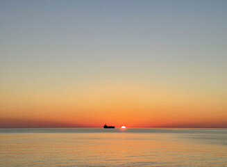 Fototapeta na wymiar Bright sunset sky, sea and ferry, ocean landscape