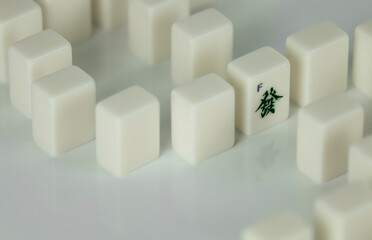 Still life of mahjong tiles on dollar sign with Chinese character Fa which means wealth