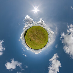 green tiny planet in blue sky with beautiful clouds with transformation of spherical panorama 360 degrees. Curvature of space.
