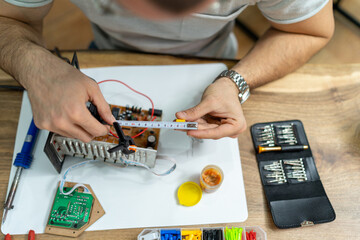 The young master electronics engineer checks, repairs and finishes the motherboard he was given to...