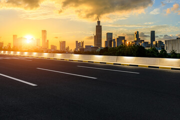 Fototapeta premium Asphalt road and city skyline with modern buildings at sunset in Ningbo, Zhejiang Province, China.