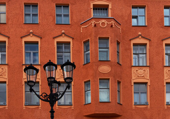 Obraz premium Typical building facade orange color with windows and old lantern in Saint-Petersburg, Russia