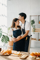 Happy asia young couple cooking together with vegetables with Bread and fruit in cozy on table...