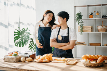 Happy asia young couple cooking together with vegetables with Bread and fruit in cozy on table kitchen table, love and valentine ..