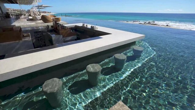 Swim up bar at infinity pool overlooking ocean at beachfront resort