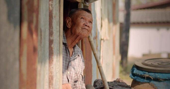 The Asian male farmer who is a poor elderly native looked up at the sky as though something had happened. Used in humanity, documentary, lonely person, environment, concepts, or movies.
