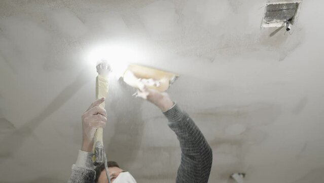 hand sanding of the plasterboard ceiling with a trowel