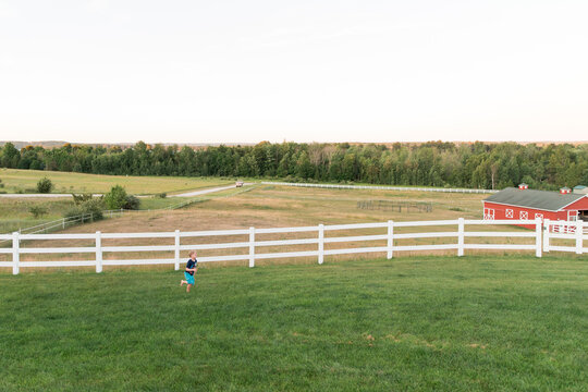 Young Blonde Boy Runs Across Farm Field in Traverse City, Michigan