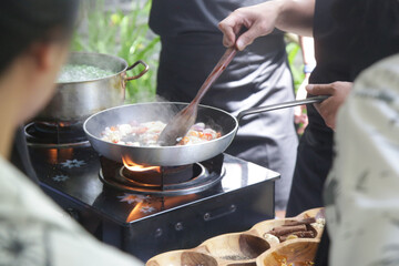 Adult students learning recipe and preparing meal in cooking class