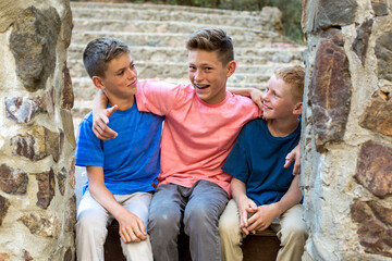 Two younger brothers look at older brother who is smiling