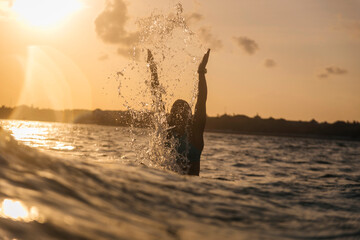 Female surfer in the ocean at sunset