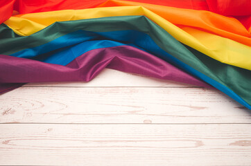 The rainbow flag or LGBTQ flag on a wooden table