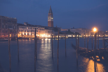 Venice canal with historical buildings and gondolas at night. Italy.
