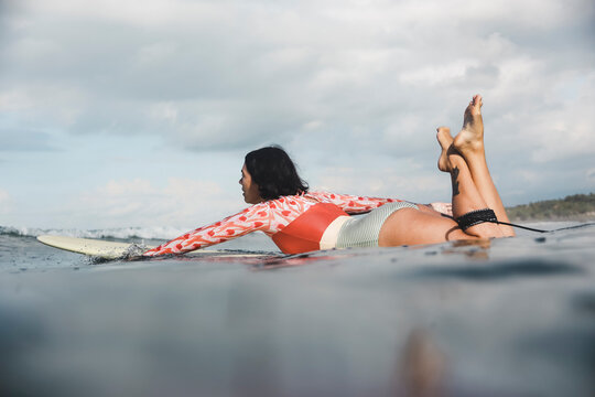 Female surfer lying on surfboard