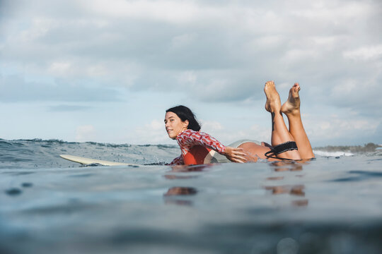 Female surfer lying on surfboard