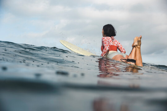 Female surfer lying on surfboard