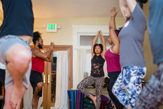 A female yoga instructor leads students in relaxation techniques