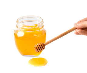 Honey in glass jar and dipper on white background