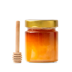 Honey in a jar with a wooden dipper on a white isolated background.