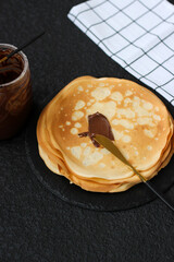 Spread sweet paste on a crepe or blini. Snack with nut, chocolate, sweet paste for breakfast