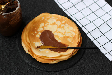 Spread sweet paste on a crepe or blini. Snack with nut, chocolate, sweet paste for breakfast