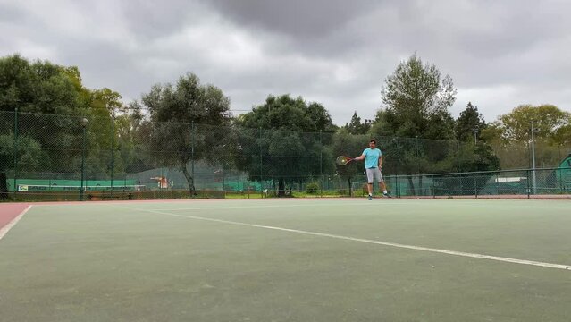 Slow motion footage of a tennis match between the male player and his instructor. man wearing blue skirt and gray shorts hits the ball. High quality 4k images