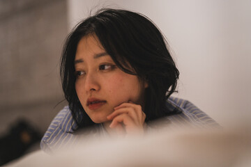 ベッドの上で寂しげな表情を見せる女性