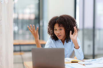 Beautiful businesswoman having video call on laptop computer in office.