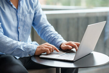 Businessman sitting using laptop computer on table in office.