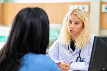 Young female doctor discus with lady patient on healthy problem at hospital clinic