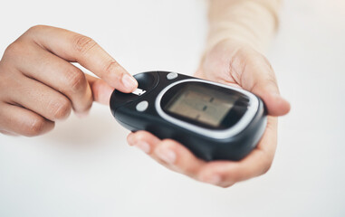 Diabetes, blood test and medical with finger of woman for insulin level, monitoring and glucose check. Medicine, healthcare and digital with hands of patient and glucometer machine for sugar balance