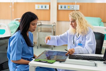 Fototapeta premium Young female doctor discus with lady patient on chest x-ray at hospital clinic