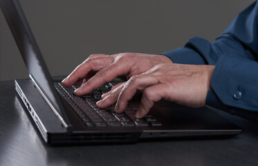 Man's hands typing on laptop