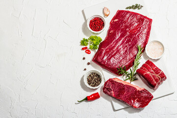Set of various steaks with spices and herbs. Eye round, flank and striploin steaks