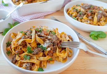 Pasta with beef stew and vegetables on plates